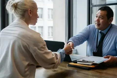 Zwei Geschäftsleute geben sich über dem Tisch die Hand