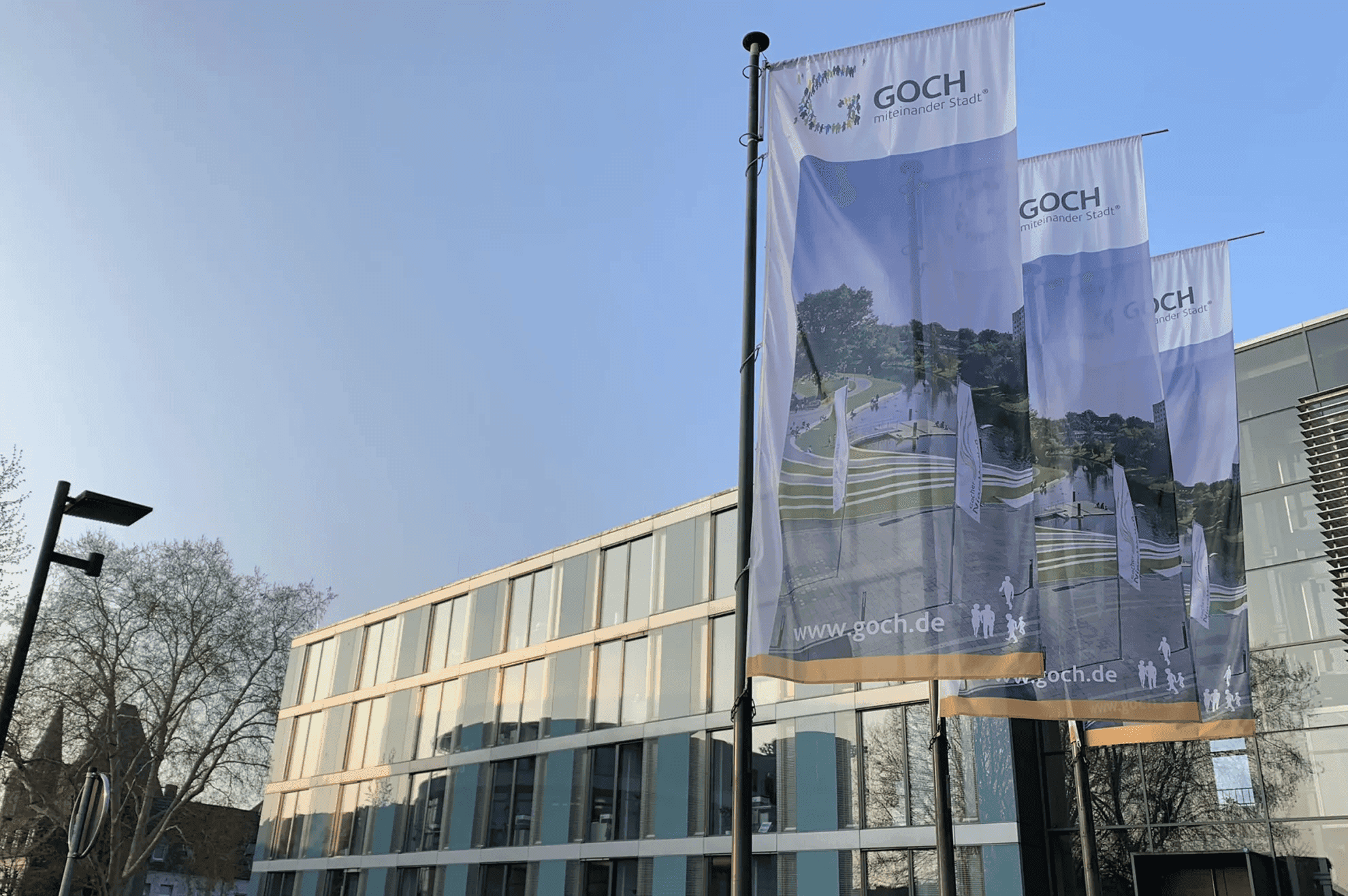 Das Rathaus der Stadt Doch mit wehenden Flaggen davor.