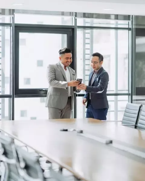 Zwei Kollegen besprechen sich im stehen neben einem Tisch